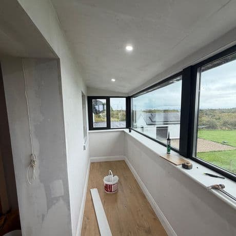 Inside the new room: wide black-framed picture windows and a corner window overlooking the garden