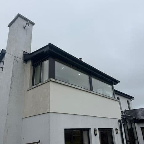 New wide black-framed picture windows and a corner window on a rendered first-floor extension