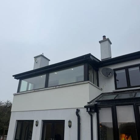 Rear of a house with a new first-floor extension and large black-framed picture windows fitted by KRB Construction & Windows