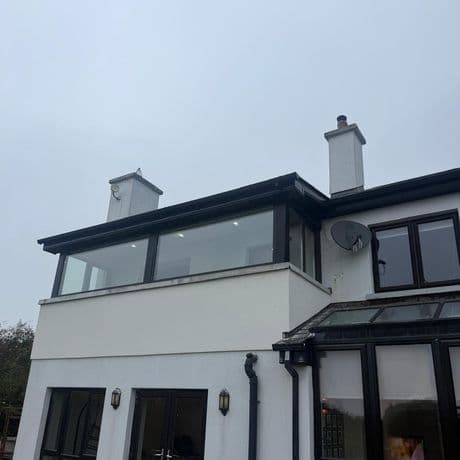 Black-framed picture windows on a first-floor extension, seen from the garden